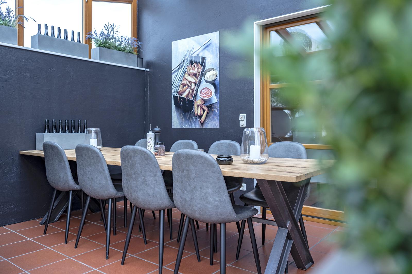 Wintergarten im BBQ Raum Hürth – heller Event- und Tagungsraum aus anderer Perspektive mit Blick auf Sitzgruppe und Fensterfront